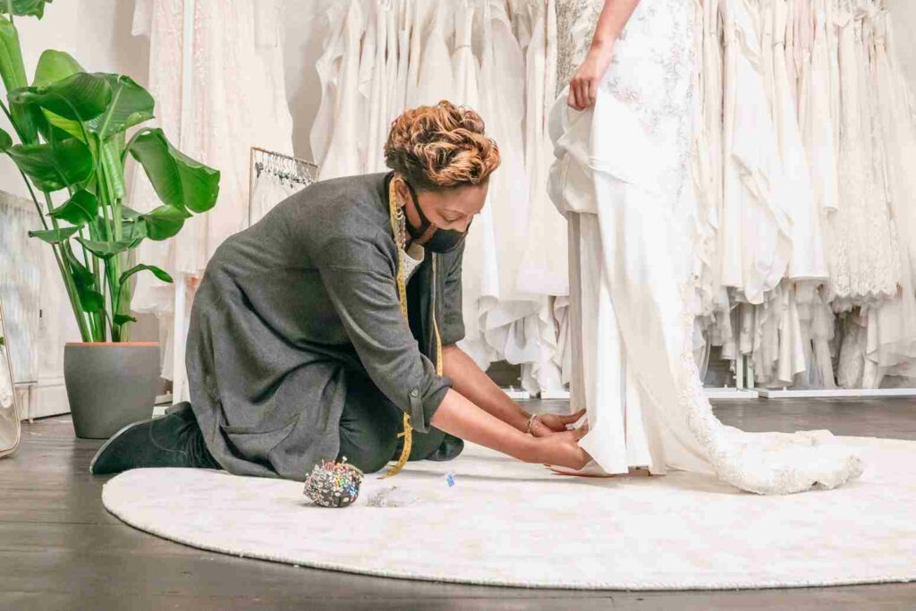 Pinning the hem of a Wedding Dress in our bridal boutique in London