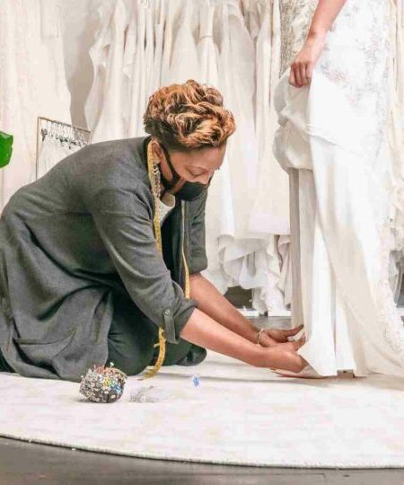 Pinning the hem of a Wedding Dress in our bridal boutique in London