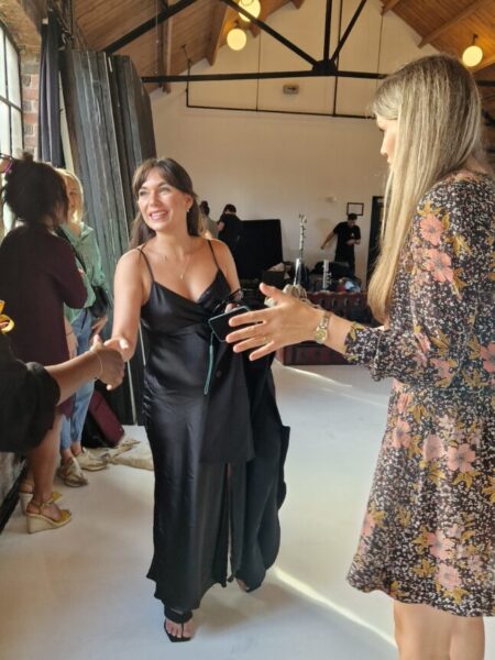 Sabrina from Love is Blind shaking hands with Marie and Caroline from Evelie before getting her body measurements taken. 