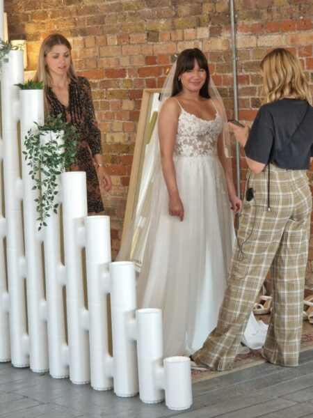 Sabrina from Love is Blind UK wearing her wedding dress with Caroline Black from Evelie in the changing room. 